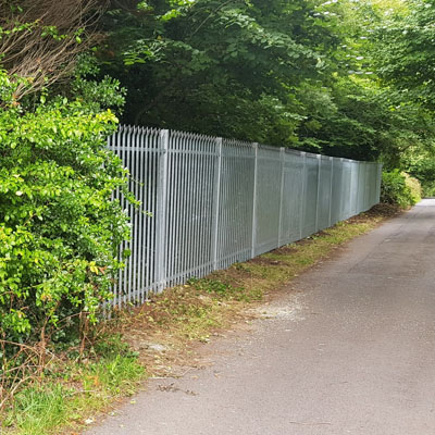Commercial palisade fencing separating pedestrian path from private property boundary