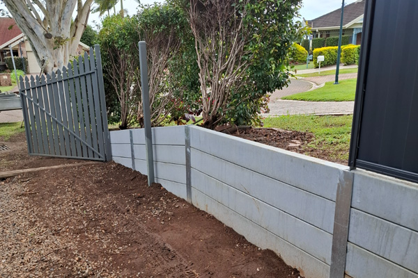 Concrete sleeper retaining wall being constructed