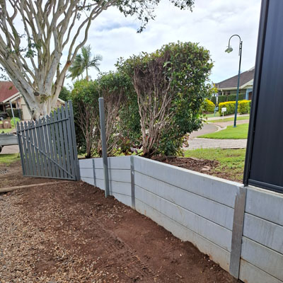 Concrete sleeper retaining wall being constructed